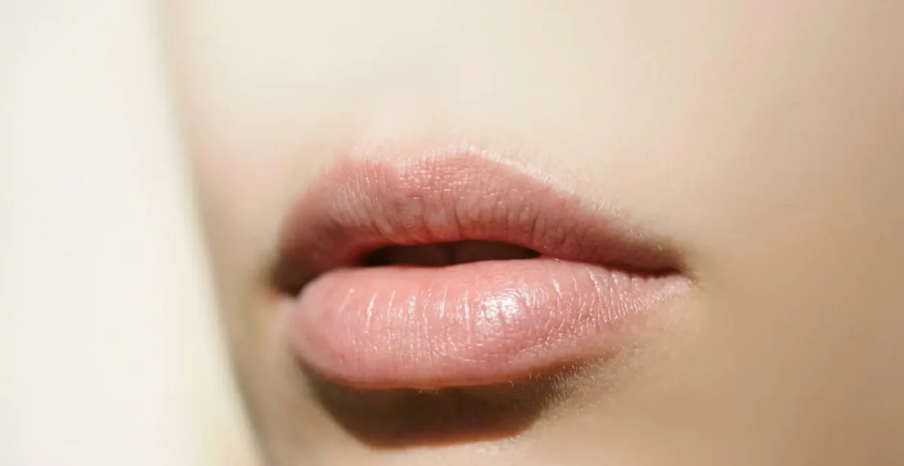 Primer plano de labios saludables con textura natural suave y bien hidratada sobre fondo minimalista