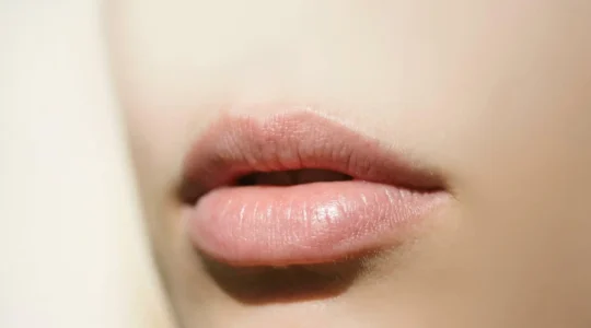 Primer plano de labios saludables con textura natural suave y bien hidratada sobre fondo minimalista