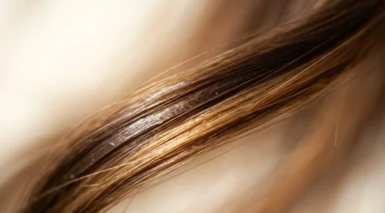 Primer plano detallado de cabello femenino mostrando textura sedosa y saludable con tratamiento capilar