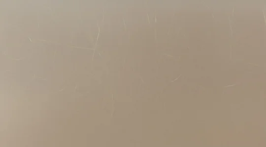 Aplicación de protector térmico en spray sobre cabello liso antes de usar plancha, concepto de protección capilar contra el calor